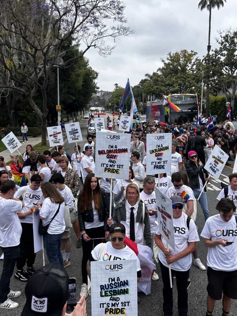 A photo of the Transgender Advisory Board posing inside a tent with a trans flag, including Mother Karina Samala and Blossom Brown. Credit: Blossom Brown