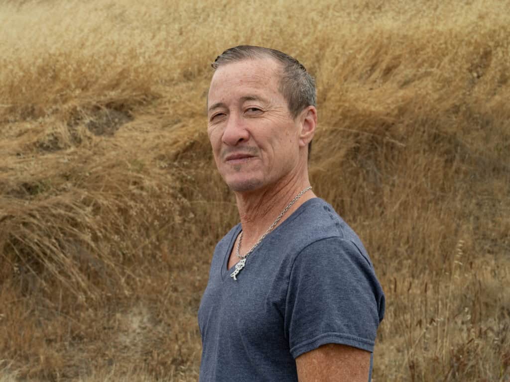 Willy Wilkinson looking directly at the camera with a golden field behind him.