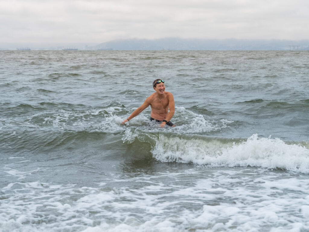Willy Wilkinson playing in the ocean with waves around him.