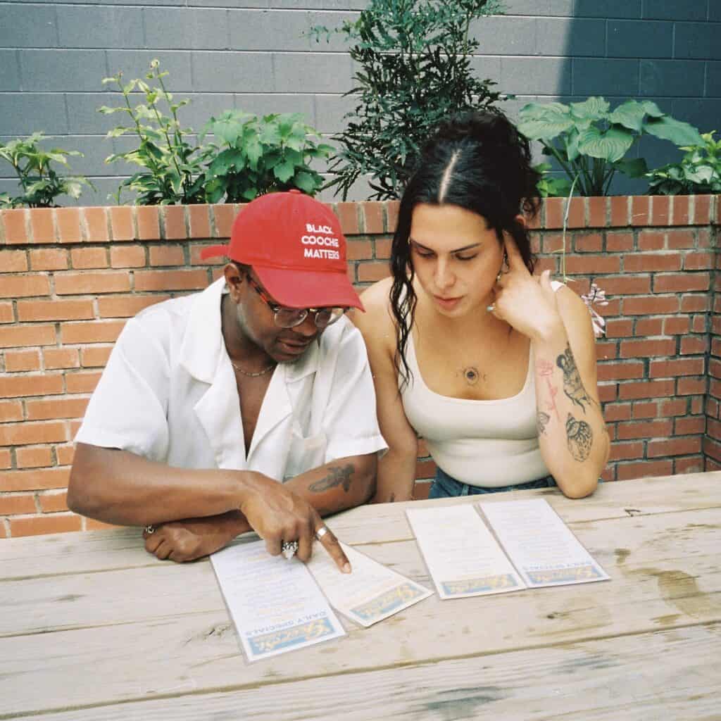 Miss B Haven and Wilson sitting at a table looking at a menu.