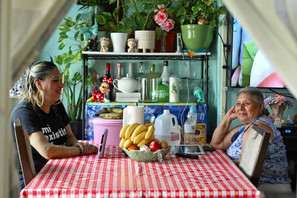 Joselyn Mendoza sits at a table with another woman.