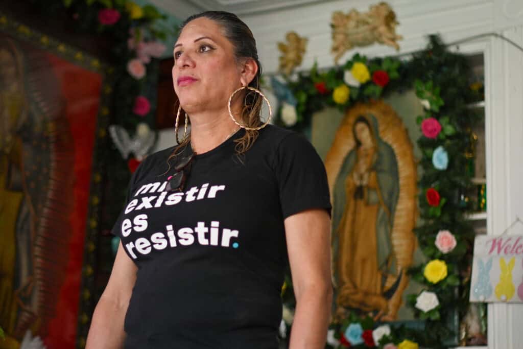 Joselyn Mendoza with a serious face looks off in the distance as she stands in a room.