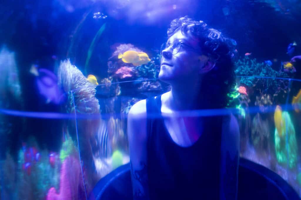Morgan Peterson (they/them) inside the aquarium at Sertoma Park in Sioux Falls, SD.